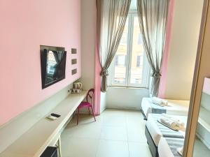 Cette petite chambre est dotée de murs roses et d'un miroir. dans l'établissement Manin Suites LT, à Rome