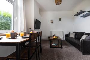 a living room with a table and a couch at Little Haven in Falmouth