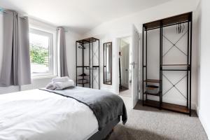 een witte slaapkamer met een groot bed en een raam bij Little Haven in Falmouth