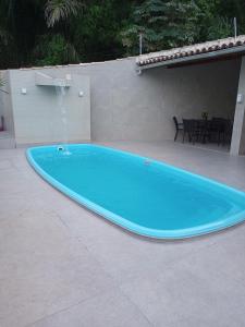 una gran piscina azul con una fuente de agua en Apart - em frente á praia dos milionários- Ilhéus, en Ilhéus