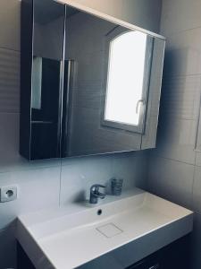 a bathroom with a sink and a mirror at Maison de charme et accueillante in Chalifert