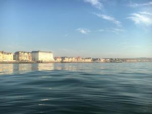 un cuerpo de agua con una ciudad en el fondo en Joli Studio proche plage et centre avec parking, en Wimereux