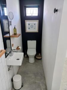 a bathroom with a white toilet and a sink at Yellow Door Hermanus in Hermanus