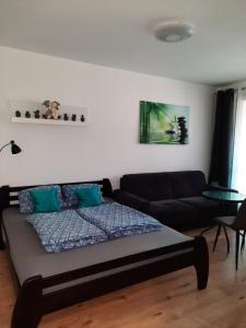 a living room with a bed and a couch at Apartment Klimka with balcony and free parking in Bratislava