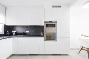 a kitchen with white cabinets and an oven at Sunset II in Santa Pola