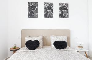 a bedroom with a bed with two black and white pillows at Sunset II in Santa Pola