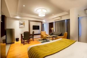 een hotelkamer met een bed en een woonkamer bij Freesia By Express Inn in Pālghar