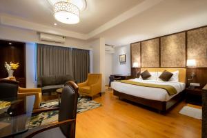a hotel room with a bed and a living room at Freesia By Express Inn in Pālghar