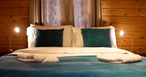 a bed with two pillows and two lamps on it at The Steadings Log Cabins in Kettlebridge