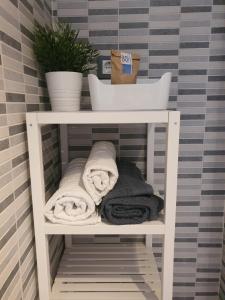 a shelf with towels and a plant in a bathroom at Precioso Estudio con Piscina in Málaga