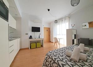 a bedroom with a bed and a kitchen and a living room at Precioso Estudio con Piscina in Málaga