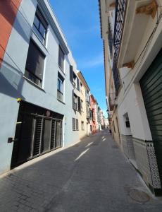 een lege straat in een steegje tussen gebouwen bij Precioso Estudio con Piscina in Málaga