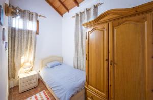 una piccola camera con letto e armadio in legno di La Palma a San Juan de la Rambla