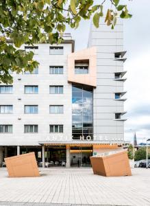 a large white building with two benches in front of it at Hotel Antik San Sebastián in Donostia-San Sebastián