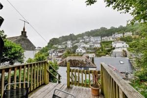 a wooden deck with a view of a town at Cosy Bake Cottage, Great Location in Looe, Cornwall in Looe