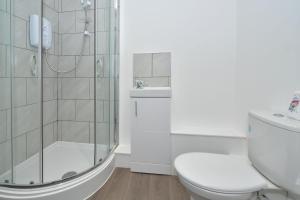 a bathroom with a shower and a toilet and a sink at Townhouse @ 24 Brunswick Place Stoke in Etruria