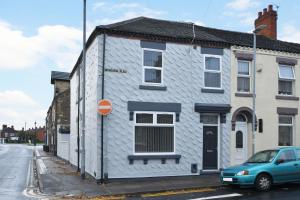 a white house with a blue car parked in front of it at Townhouse @ 24 Brunswick Place Stoke in Etruria