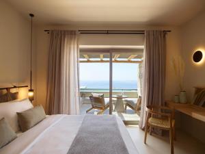 a bedroom with a bed and a view of the ocean at Collini Suites & Villas Mykonos in Fanari