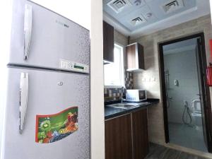 a kitchen with a refrigerator and a kitchen with a sink at Barsha Star Residence - Home Stay in Dubai