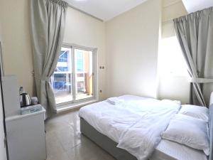 ドバイにあるBarsha Star Residence - Home Stayの白いベッドと窓のある寝室