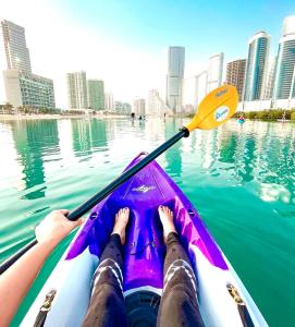 a person is paddling a kayak in the water at Upgraded 2 bedrooms to 3 bedrooms Private Residential Apartment In C4 Tower in Hydra Avenue Towers in Al Reem Island - 1307 in Abu Dhabi