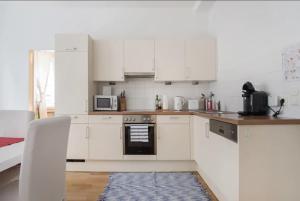 cocina con armarios blancos y fogones en Apartment France | Operastreet en Viena