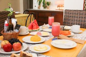 - une table avec des assiettes de nourriture et des fruits dans l'établissement Pousada Mucuripe, à Fortaleza