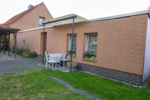 a house with a table and chairs in the yard at Ferien am Bierbach in Eldena