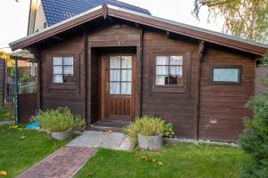 uma pequena casa com uma porta de madeira e janelas em Ferien am Bierbach em Eldena