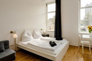 a white bed in a room with a window at Lovely Studio near Naschmarkt in Vienna