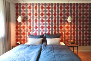 - une chambre avec un lit bleu et un mur géométrique dans l'établissement Ferienwohnung 60er Jahre Design Apartment - 65qm Fewo im Zittauer Gebirge - familienfreundliche Unterkunft am Bergfuß zum Töpfer, à Olbersdorf