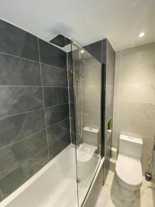 a bathroom with a toilet and a glass shower at Stunning 1-bedroom apartment in Central Norwich in Norwich