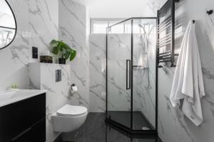 a bathroom with a toilet and a glass shower at Old Town Residence - Premium Aparthotel in Krakow