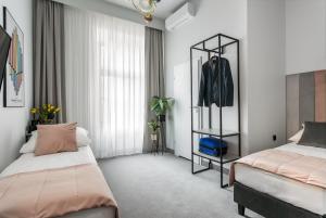 a bedroom with two beds and a suit on a rack at Old Town Residence - Premium Aparthotel in Krakow