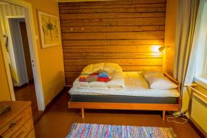 a small bed in a room with a wooden wall at Most photographed house in Reine in Reine