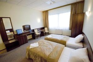 a hotel room with two beds and a mirror at Hotel A4 MOP Kępnica in Jaworzno