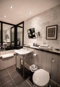 a bathroom with a toilet and a sink and a mirror at The Dower House Hotel in Woodhall Spa