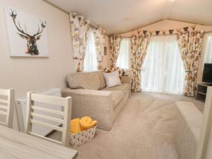 a living room with a couch and a tv at Rubys Retreat in Leek