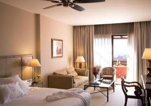 Habitación de hotel con cama y sala de estar. en Asia Gardens Hotel & Thai Spa, a Royal Hideaway Hotel, en Finestrat