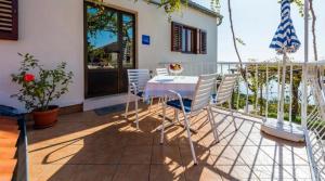 patio con mesa y sillas en el balcón en Guest House Fontana, en Mlini