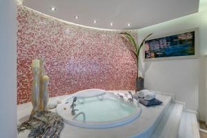 a bathroom with a bath tub in the middle of a room at Kouros Art Hotel - Designed for Adults in Stelida