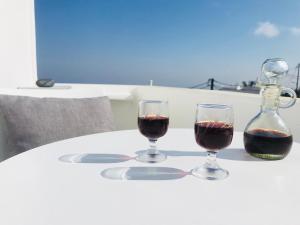 two glasses of red wine sitting on a table at Villa Fotini in Firostefani