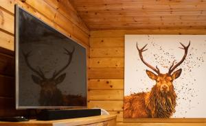 uma pintura de um veado com chifres na parede em The Steadings Log Cabins em Kettlebridge