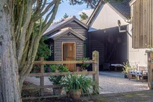 a house with a wooden gate and a fence at Secluded cottage in pretty countryside with woods & walks - Bradleys Barn in Boxted