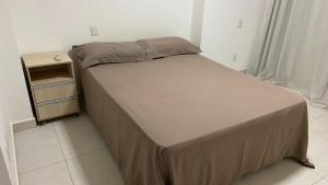 a small bed in a room with a night stand at Trend 2414 in Goiânia