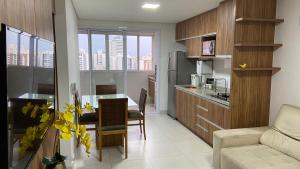 a kitchen and living room with a table and a couch at Trend 2414 in Goiânia