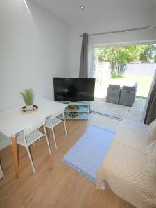 ein Wohnzimmer mit einem weißen Tisch und einem TV in der Unterkunft Turay Court Holiday Apartments in Bournemouth