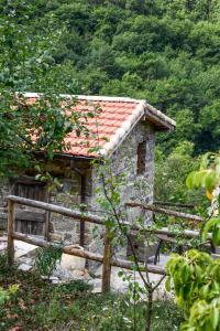 阿普里卡萊的住宿－CASA LUCERTOLA，一座红色屋顶的小石头建筑