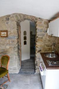a kitchen with a stone wall and a sink at CASA LUCERTOLA in Apricale