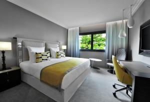 阿比让Mövenpick Hotel Abidjan的一间卧室，配有一张床、一张书桌和一台电脑
